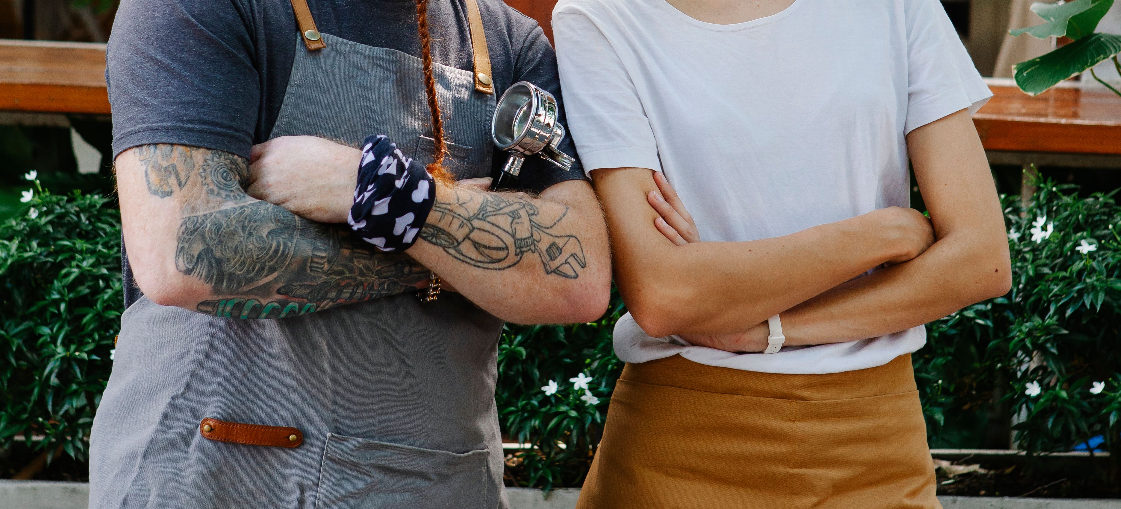 Dois profissionais de hospitalidade com tatuagens em ambiente de trabalho
